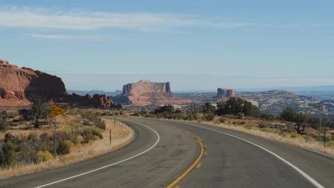 Driving On Empty Road In Amazing Arches Park In Utah With Red Rock Formations Vidéo 120015409
