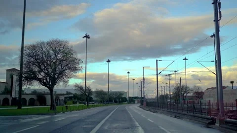 Driving on empty road in Lisbon next to tram line at sunrise Stock Footage 273673471