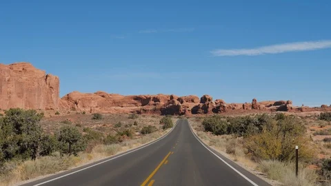 Driving On Empty Road Through Arches Park With Red Rocks Formation In Desert Usa Stock Footage 120012466