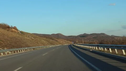 Driving on an empty scenic road at sunset, looking at glowing barrier Stock Footage 237813811