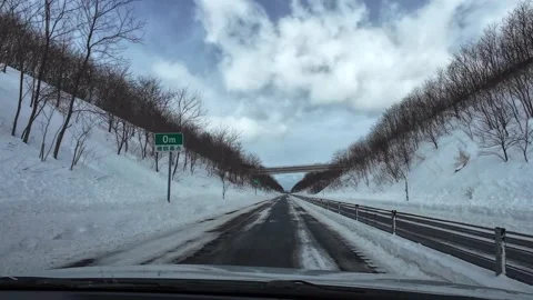 Driving on empty snowy highway under bridge in Hokkaido Japan Video stock 333091220