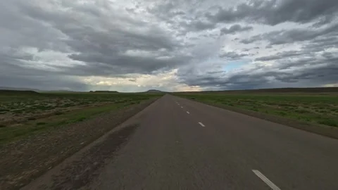 Driving forward on a paved road through flat terrain Stock Footage 345088204