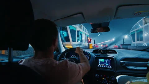 Driving at heavy rain. Man driver sits in the car and waits in a queue to pay Stock Footage 237775204