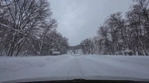 Driving in heavy snowfall with poor visibility on snowy mountain road POV Video stock 333091353