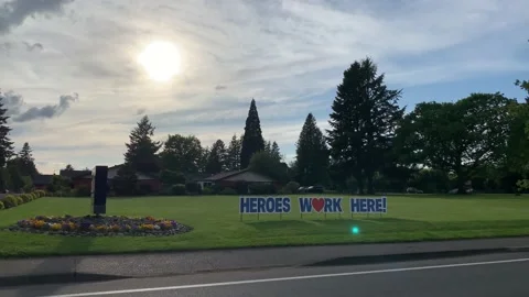 Driving by a Heroes Work Here sign at a nursing home showing appreciation. Stock Footage 130929365