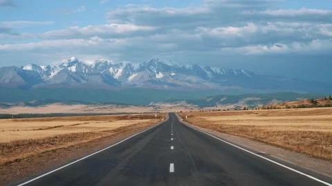 Driving On Highway Going To Mountain Range With Glaciers Through Desert Prairie Stock Footage 165727558