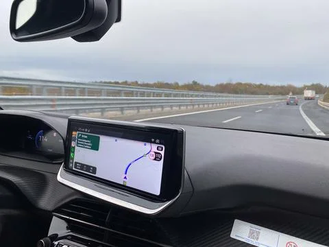 Driving on a highway with GPS navigation displayed on the car's infotainmen.. Stock Photos