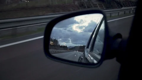 Driving on a highway looking back in side view mirror Stock Footage 103214082