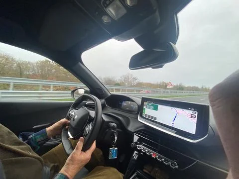 Driving on a highway with navigation system showing route on a cloudy day Stock Photos