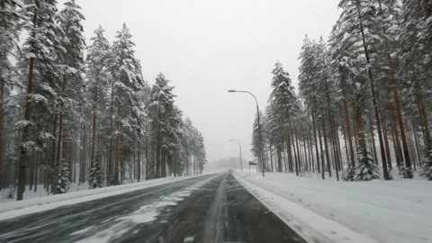 Driving on icy road through winter landscape. Bad snowy and slippery weather. Stock Footage 147972502