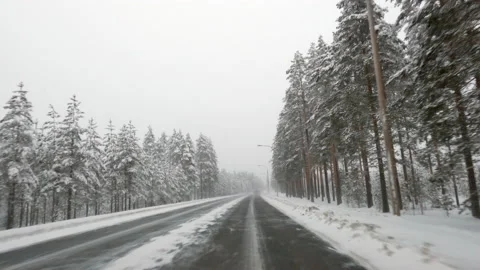 Driving on icy road through winter landscape. Bad snowy and slippery weather. Stock Footage 147976372