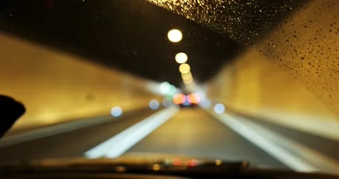 Driving inside a highway tunnel in the rain with a blurry bokeh background Stock Footage 336049438