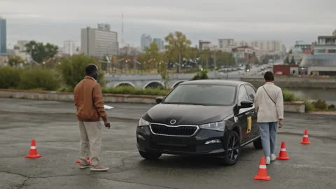 Driving Instructor Explaining Task to Young Female Learner Stock Footage 276539212