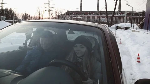 Driving instructor points out mirrors to pretty teenage girl sitting in car Stock Footage 73528302