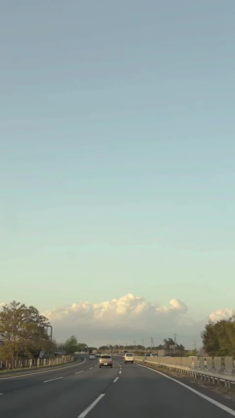 Driving on Japanese highway at dusk with dramatic cumulus clouds vertical POV Stock Footage 333226813