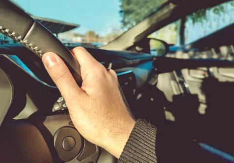 Driving learning right hand on steering wheel inside a car with left-hand Stock Photos