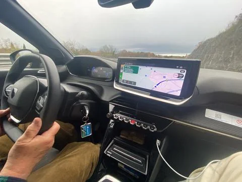 Driving a modern car with navigation system showing route on a cloudy day Stock Photos