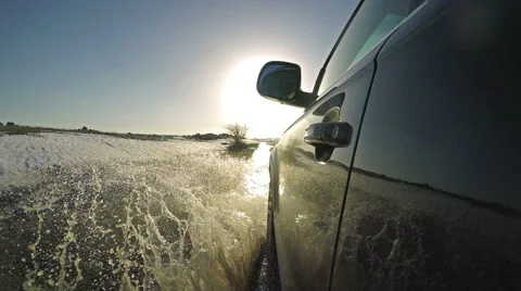 Driving on muddy road with water splashes towards camera Stock Footage 61253377