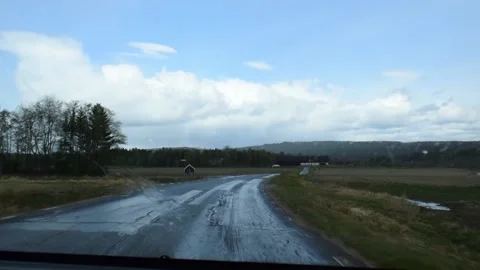 Driving on narrow bumpy country lane past acres and fields on rainy spring day Video stock 166170201
