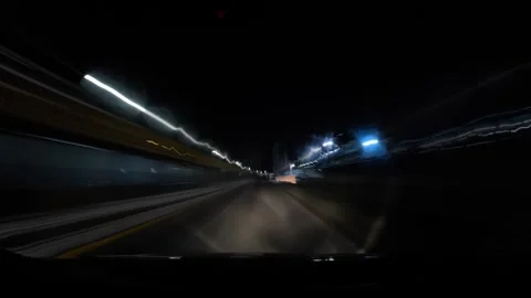 Driving at night through a busy highway with bright lights and fast-moving cars  Stock Footage 335333596