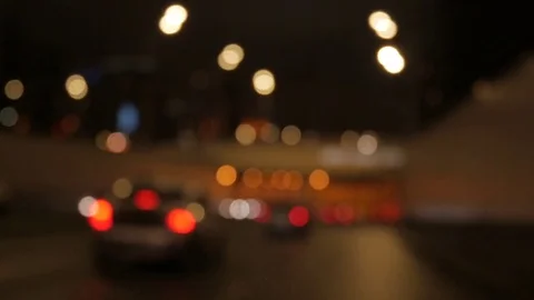 Driving at night. Windshield view and blurred cars in city. Illuminated front ca Stock Footage