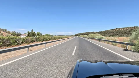 Driving on open rural highway under clear blue sky Stock Footage 332064815