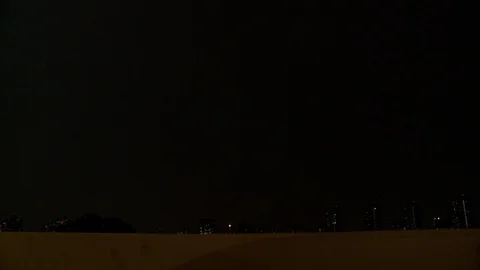Driving over bridge with view of NYC during thunder and lightning storm, night. Video stock 107992890