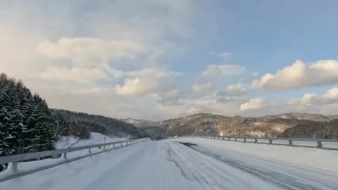 Driving over a road bridge through snowy winter forest landscape Stock Footage 265637963