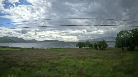Driving past coastal fields and fjord mountain panorama in Andoya Norway Stock-Footage 343380098