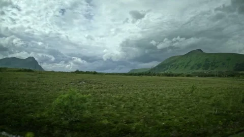 Driving past empty asphalt road turn and green plains in Andoya Norway Stock-Footage 343131357
