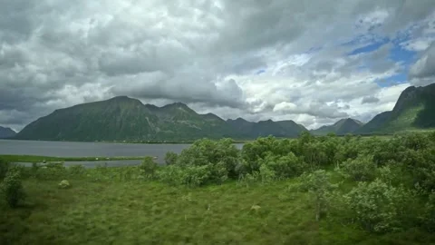 Driving past green birch forest and fjord mountain panorama in Andoya Norway Vídeos de archivo 343380139