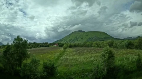Driving past green meadows red house and rounded mountain peak in Andoya Norway Stock-Footage 343131375