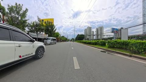 Driving past greenery and shops on Saigon street, Vietnam Stock Footage 314946316