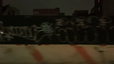 Driving past gritty graffiti on boarded up construction site New York City NYC Stock Footage 148504711