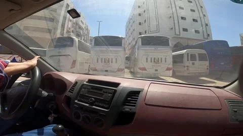 Driving Past Large Passenger Buses and Urban Buildings Stock Footage 333076841