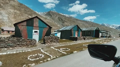 Driving Past Mountain Huts in a High Altitude Himalayan Valley Under Blue Sky Stock Footage 338212302