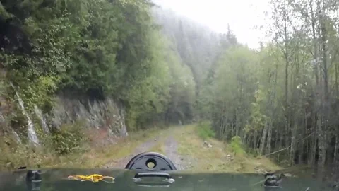 Driving past multiple waterfalls on logging road Stock Footage 172560964