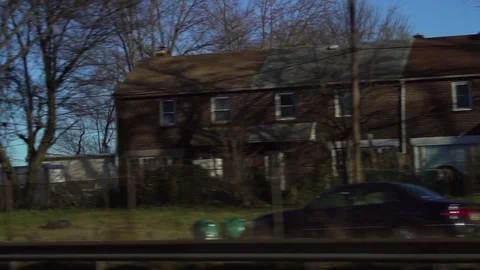 Driving past row homes on a highway Stock Footage