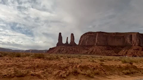 Driving Past Setting Hen Rock in Monument Valley at Golden Hour Stock Footage 309048836