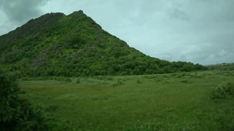 Driving past Sortland 97 road sign and green mountain peak in Andoya Norway Vidéo 343131325