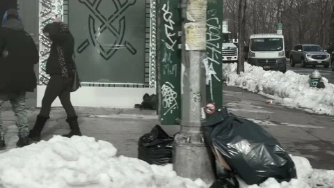 Driving past trucks homeless person sitting on sidewalk snow New York City NYC Stock Footage