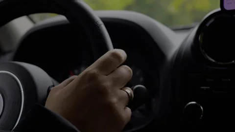 Driving perspective inside a car showing hand on steering wheel... Stock Footage 319881144