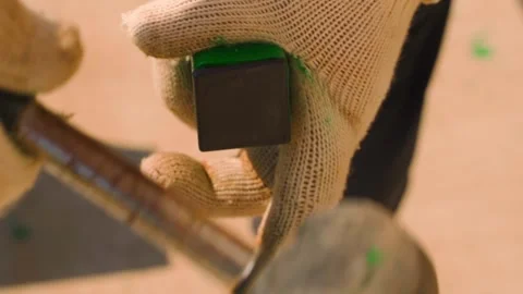 Driving a plastic plug into a metal square pipe, close-up in slow motion Stock Footage 313578244