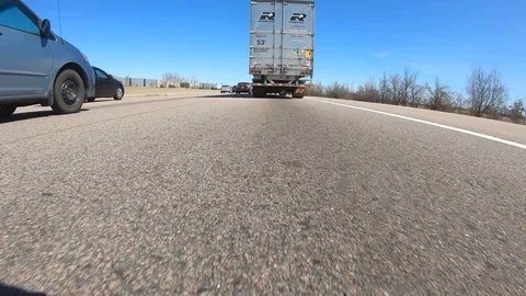 Driving plate POV low angle  highway with car and truck traffic Stock Footage 106397857