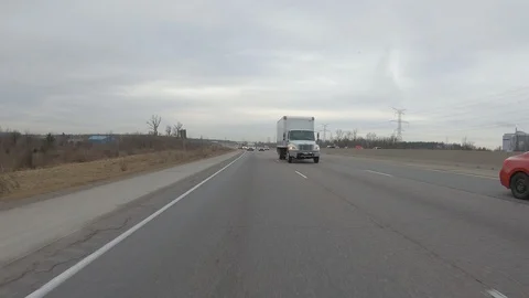 Driving plate POV reverse angle on highway with trucks cars and tractor trailers Stock Footage 100116373