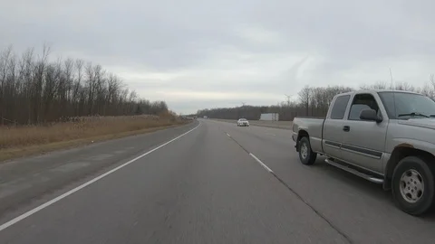 Driving plate POV reverse angle on highway with trucks cars and tractor trailers Stock Footage 100117037