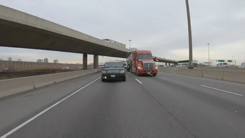 Driving plate POV reverse angle on highway with trucks cars and tractor trailers Stock Footage 100120887