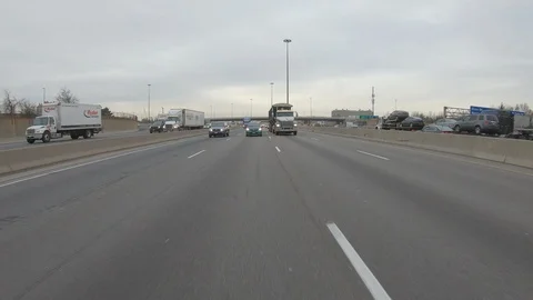 Driving plate POV reverse angle on highway with trucks cars and tractor trailers Stock Footage 100120985