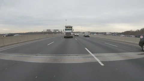 Driving plate POV reverse angle on highway with trucks cars and tractor trailers Stock Footage 100121587