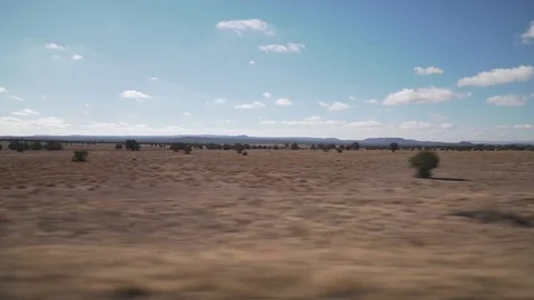 Driving plate side view moving through hills and fields Stock Footage 82976285